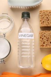 Photo of Eco friendly natural cleaners. Flat lay composition with bottle of vinegar on beige background