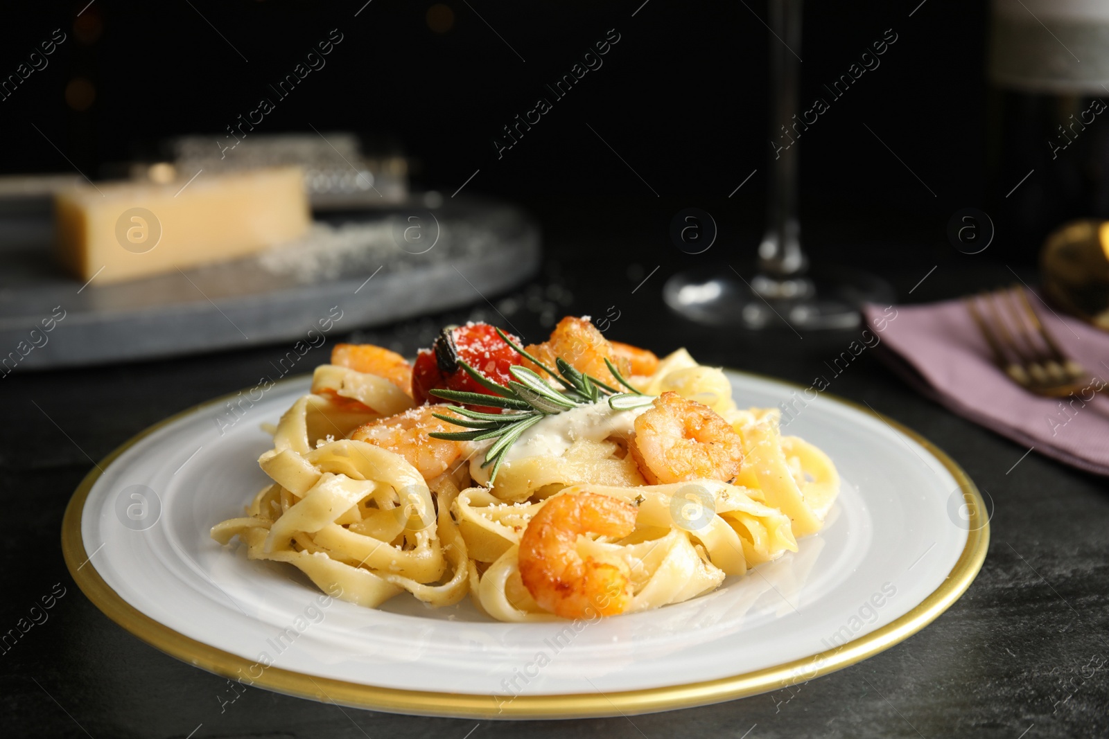 Photo of Delicious pasta with shrimps on black table