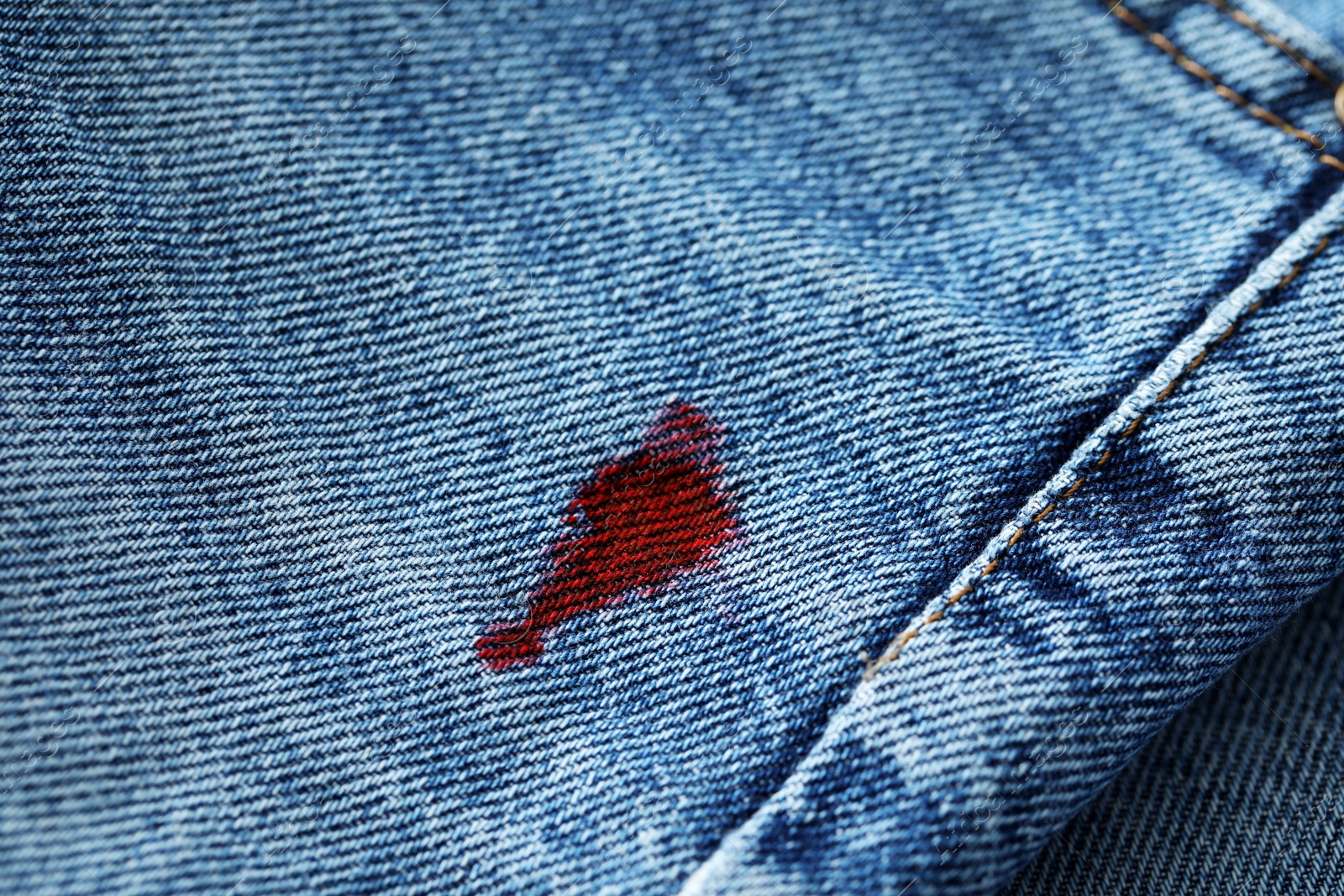 Photo of Stain of red ink on jeans, closeup