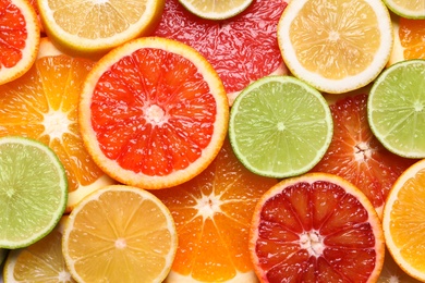 Photo of Fresh juicy citrus fruits as background, top view