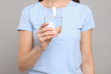 Photo of Healthy habit. Closeup of woman holding glass with fresh water on grey background