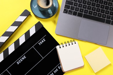 Photo of Flat lay composition with movie clapper on yellow background