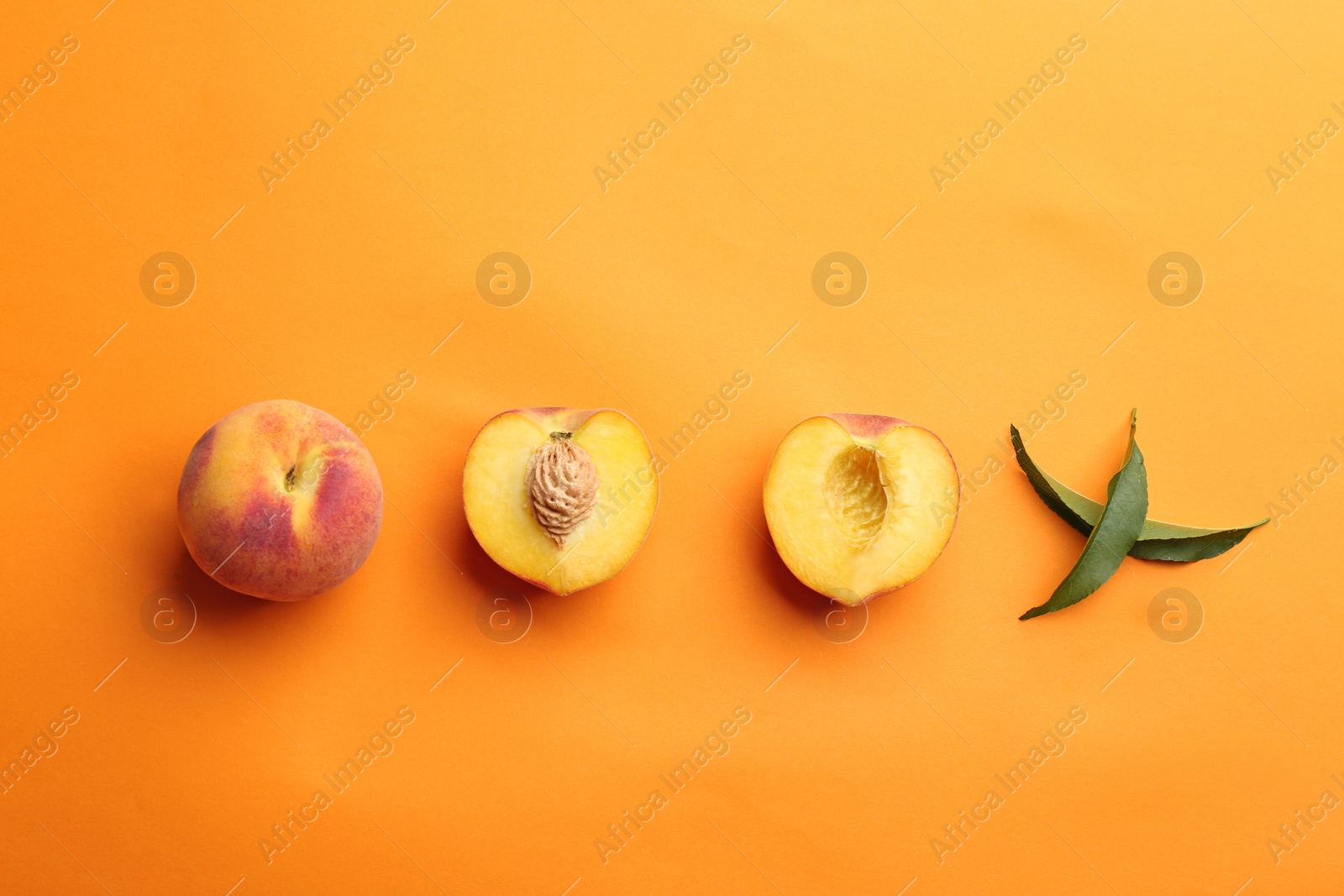 Photo of Flat lay composition with fresh peaches on orange background