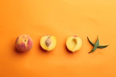 Flat lay composition with fresh peaches on orange background