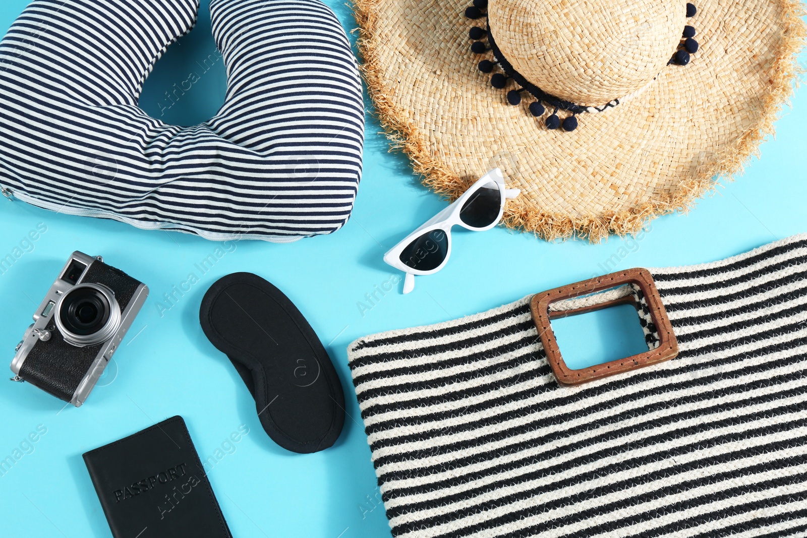 Photo of Flat lay composition with travel pillow and tourist stuff on light blue background