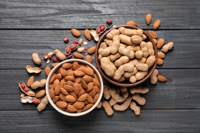 Photo of Flat lay composition with organic nuts on wooden background, top view. Snack mix