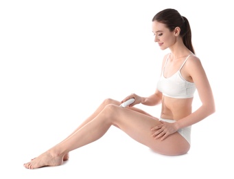 Photo of Young woman doing leg epilation procedure on white background