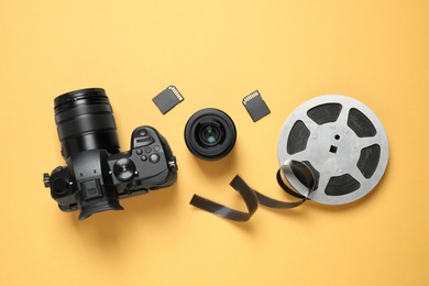 Photo of Flat lay composition with camera and video production equipment on yellow background
