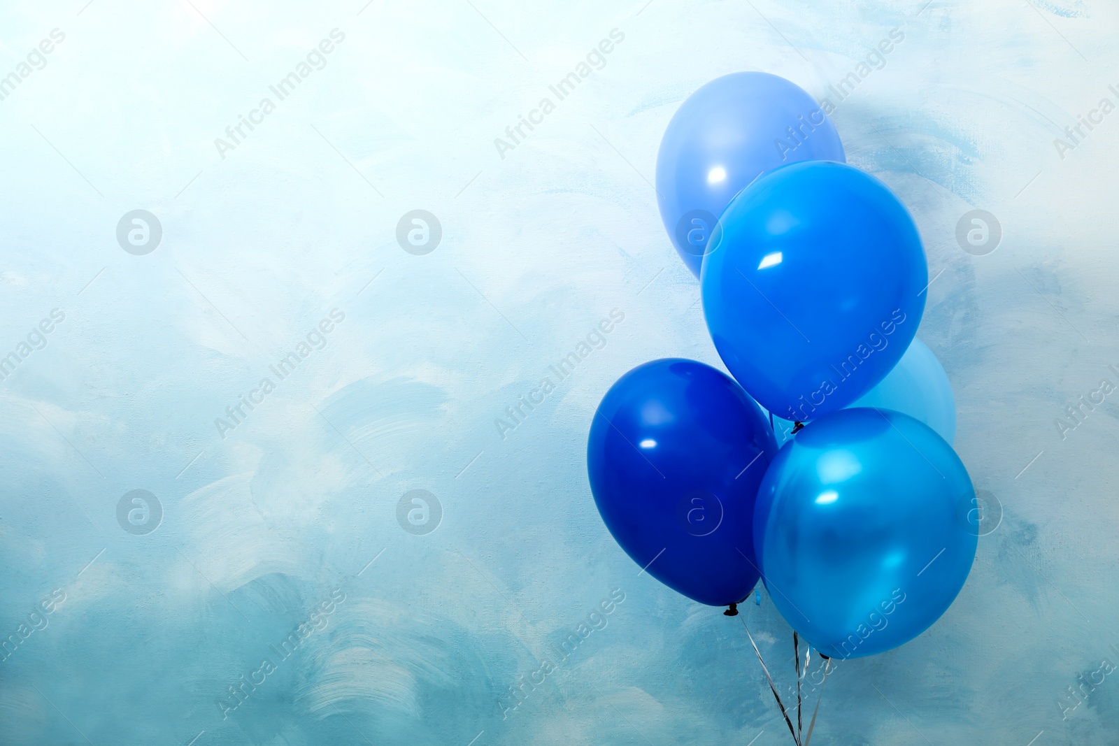 Photo of Bunch of balloons on light blue background, space for text. Greeting card