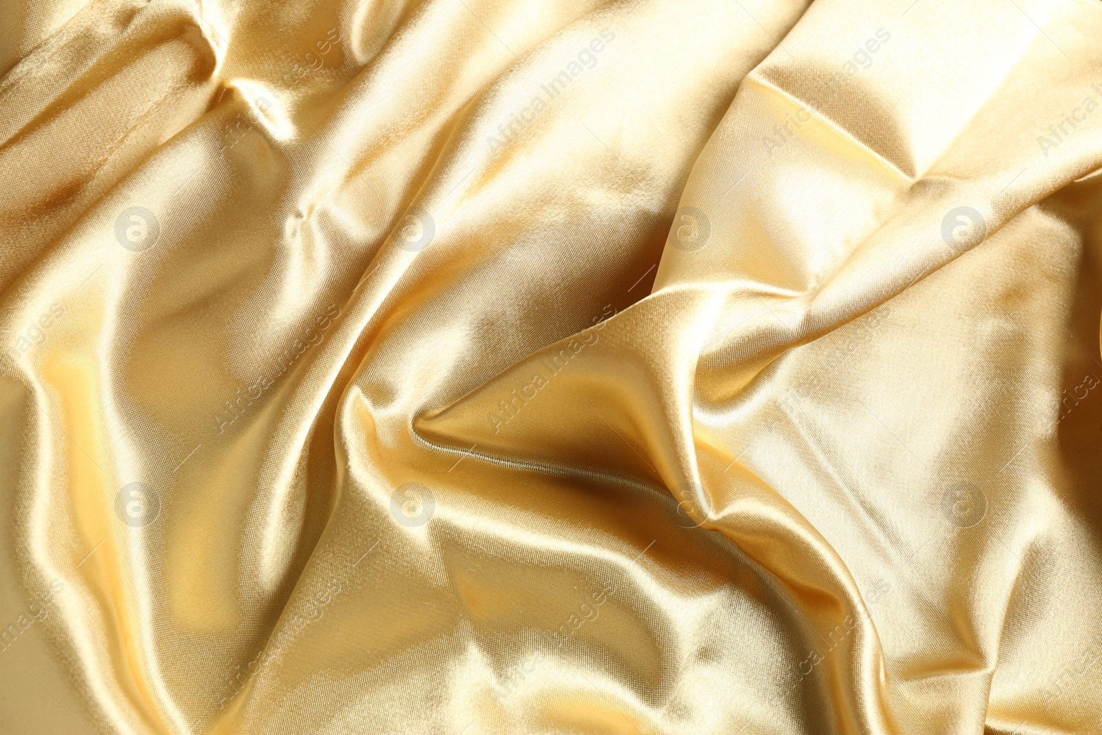 Photo of Golden shiny fabric as background, top view