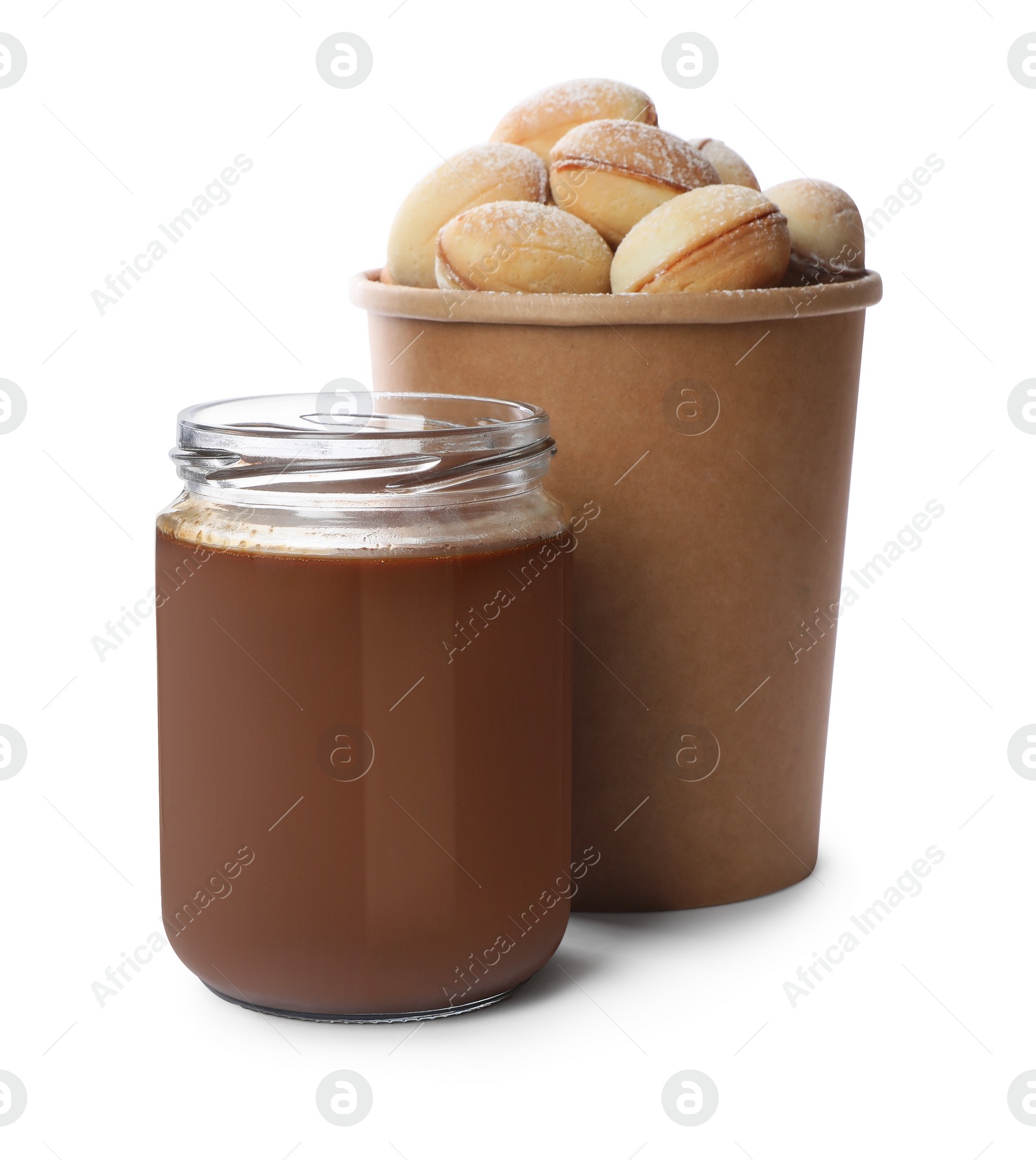Photo of Jar with boiled condensed milk and walnut shaped cookies on white background