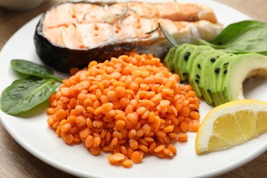 Photo of Plate with healthy food high in vegetable fats on wooden table, closeup