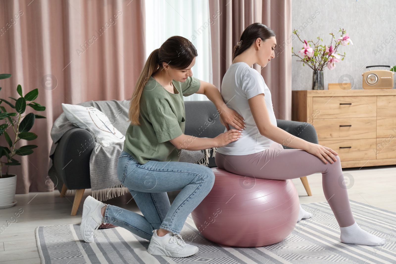 Photo of Doula massaging pregnant woman at home. Preparation for child birth