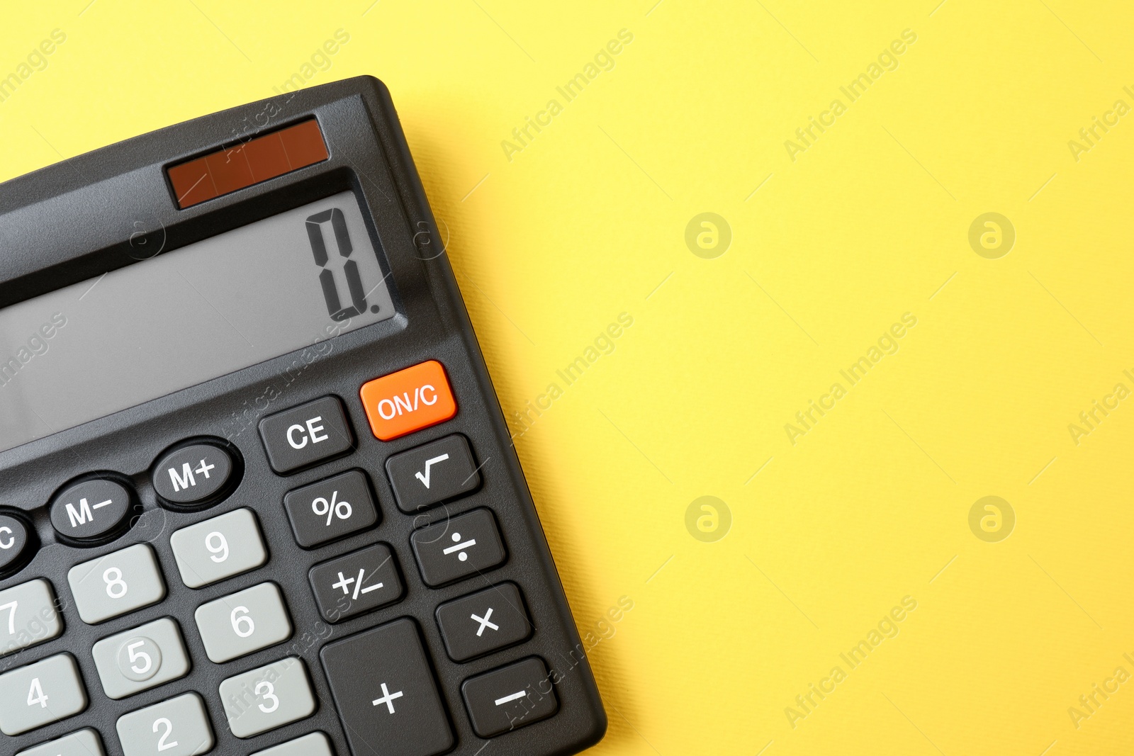 Photo of Calculator on yellow background, top view. Space for text