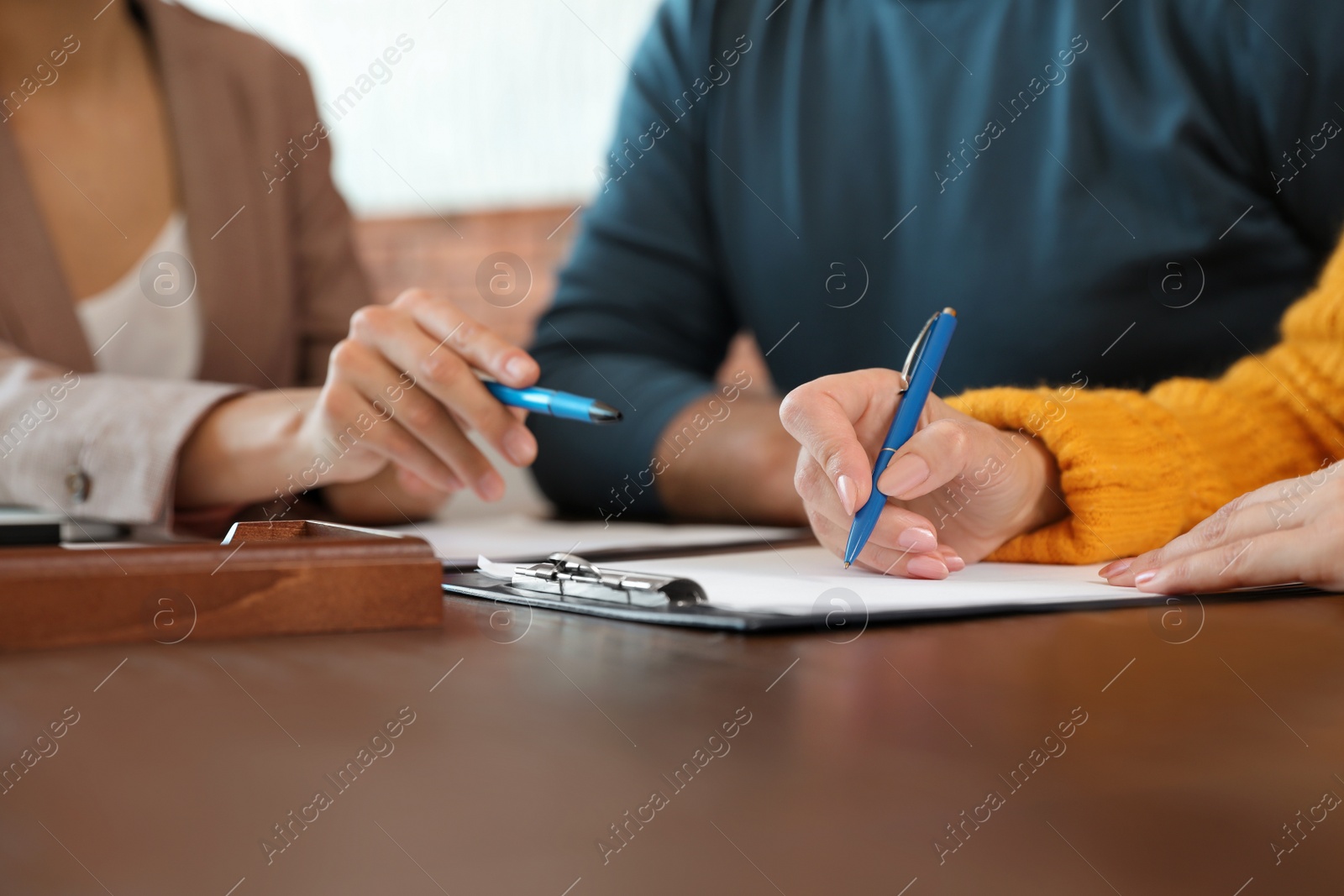 Photo of Female notary working with mature couple in office, closeup