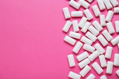 Tasty white chewing gums on pink background, flat lay. Space for text