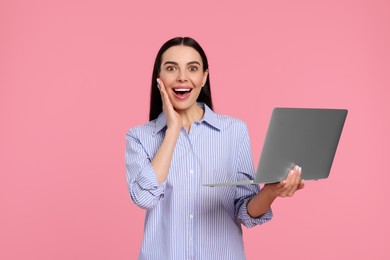 Photo of Surprised woman with laptop on pink background