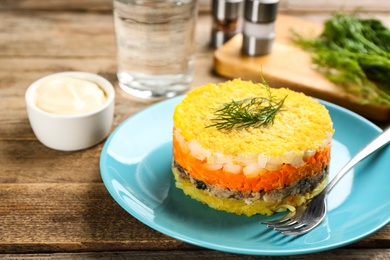 Traditional russian salad Mimosa served on wooden table