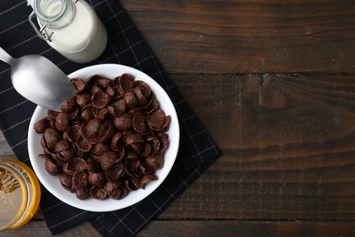 Photo of Breakfast cereal. Chocolate corn flakes served with milk and honey on wooden table, flat lay. Space for text