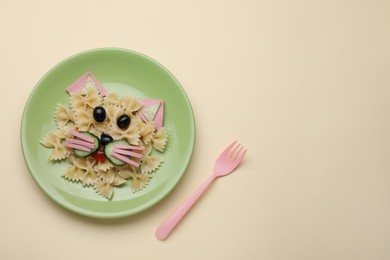 Photo of Creative serving for kids. Plate with cute cat made of tasty pasta, vegetables and sausage on beige background, flat lay. Space for text
