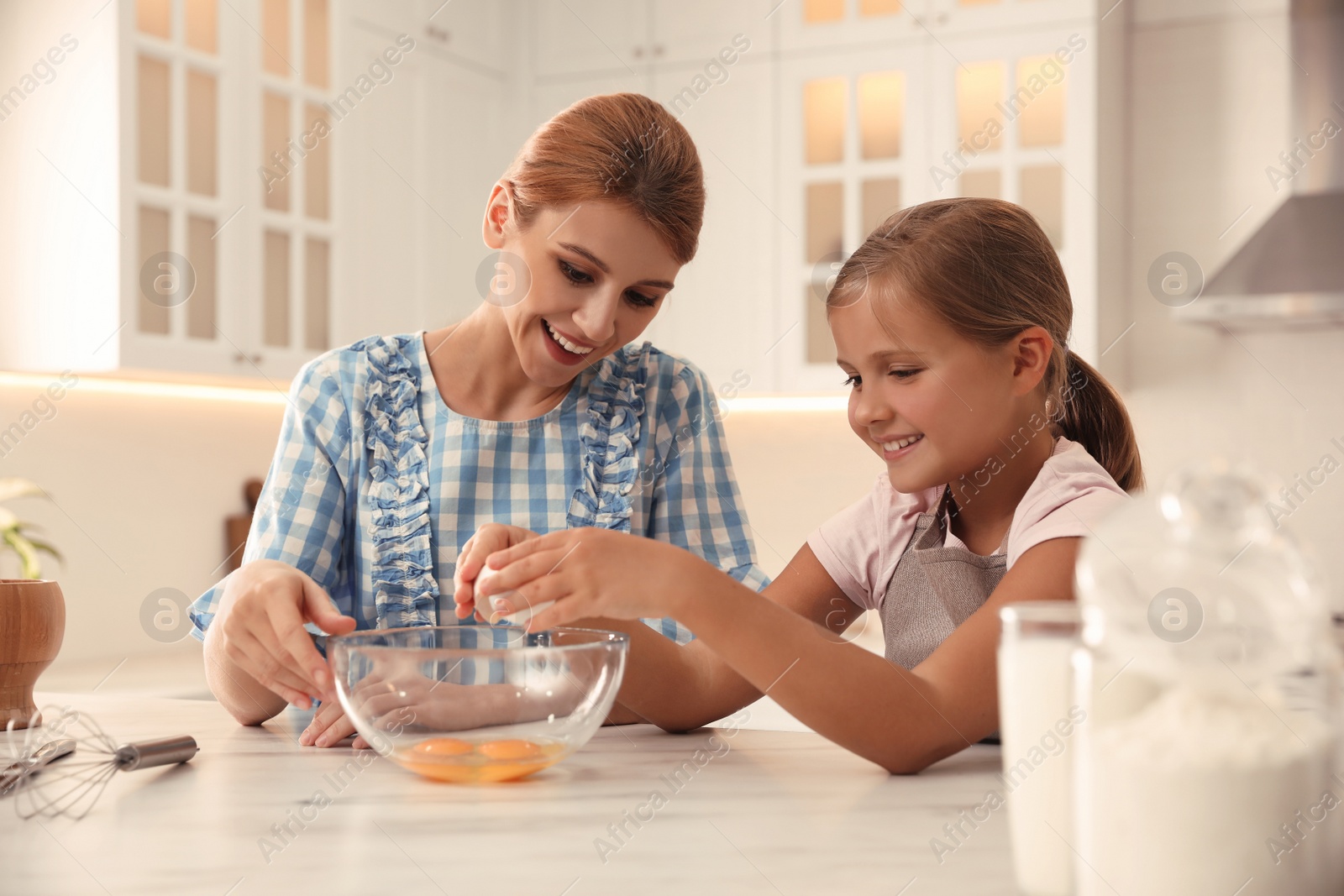 Photo of Mother and daughter making dough together in kitchen