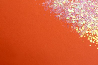 Photo of Shiny bright lilac glitter on orange background. Space for text