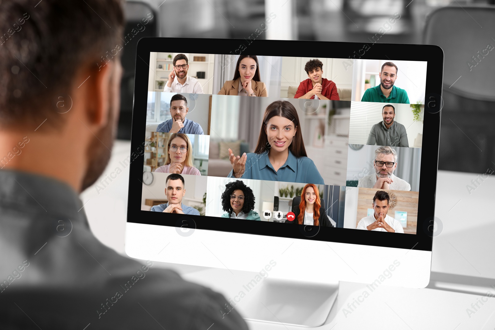 Image of Man having video chat with coworkers at office