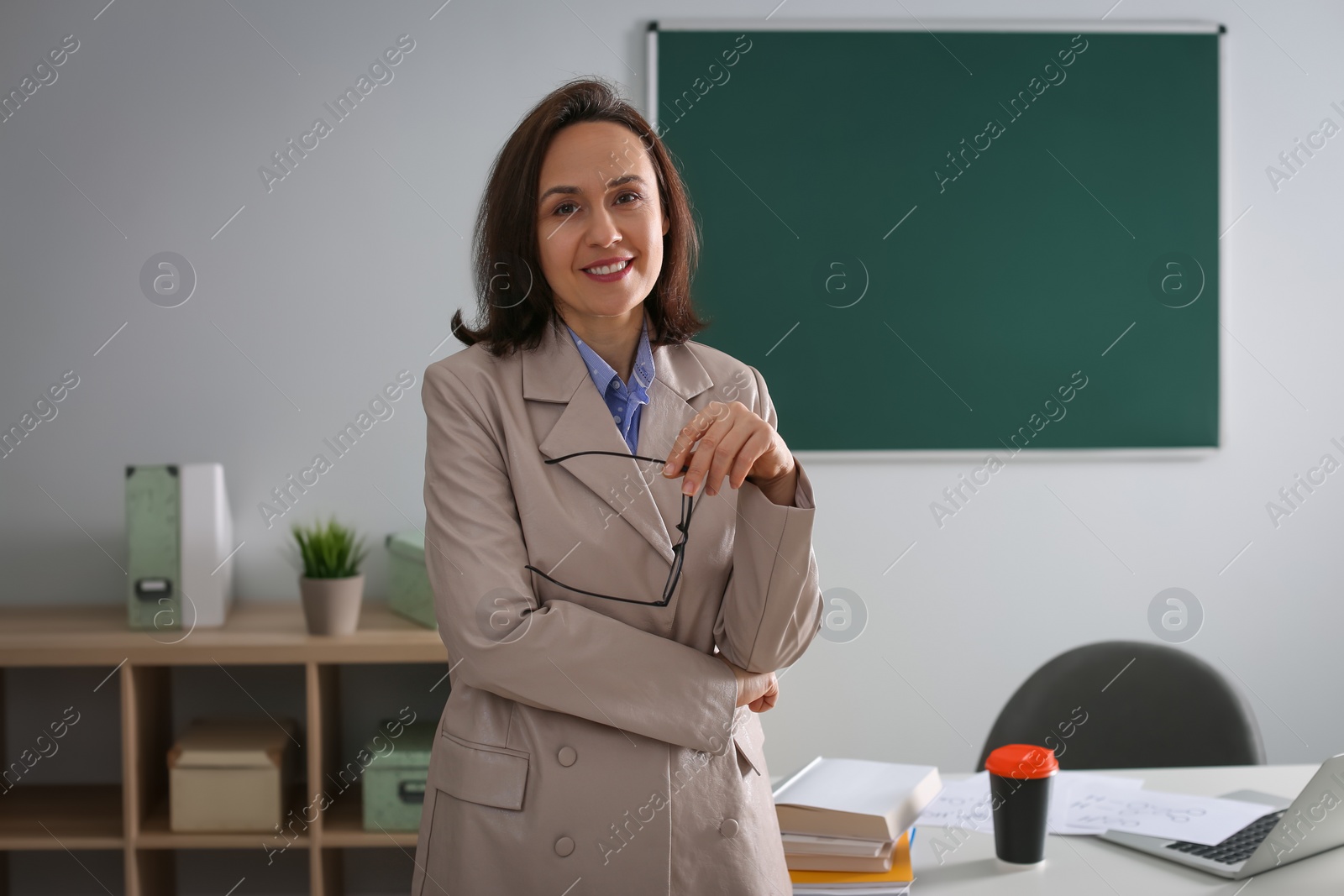 Photo of Portrait of teacher near desk in classroom