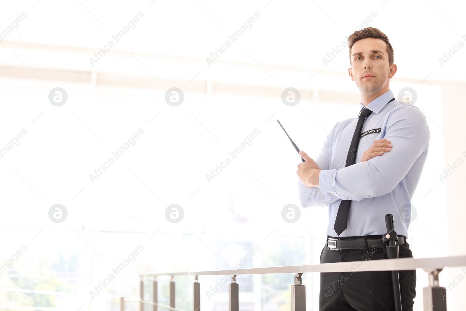 Photo of Male security guard with portable radio transmitter indoors