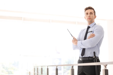 Male security guard with portable radio transmitter indoors