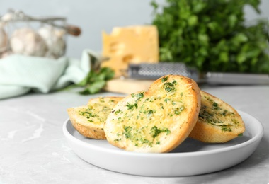 Photo of Slices of toasted bread with garlic, cheese and herbs on light table