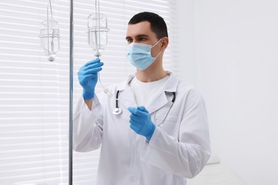 Photo of Doctor setting up IV drip in hospital