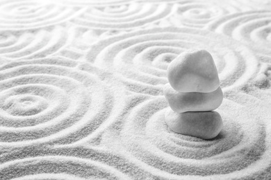 Stack of white stones on sand with pattern, space for text. Zen, meditation, harmony