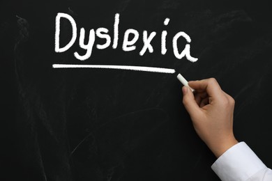 Image of Man writing word Dyslexia on blackboard, closeup