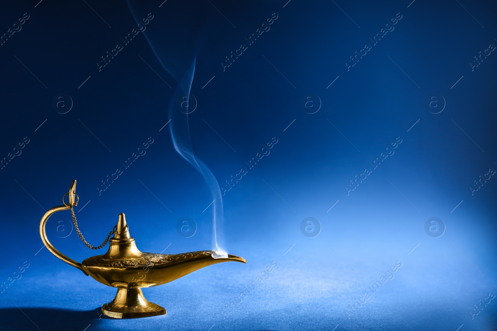 Photo of Aladdin magic lamp on blue background