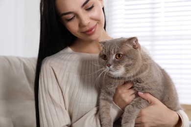 Photo of Woman with her adorable cat on sofa at home