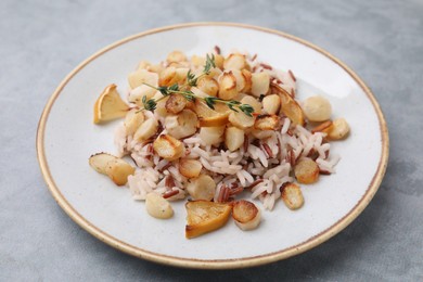 Photo of Plate with baked salsify roots, lemon and rice on light grey table, closeup