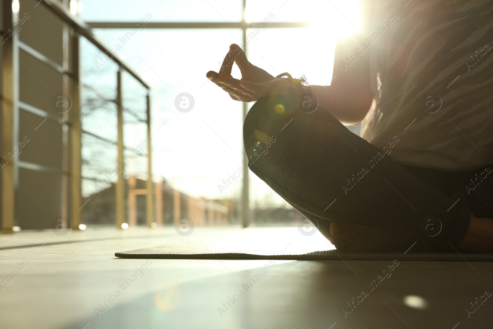 Photo of Young woman practicing yoga in sunlit room, closeup with space for text