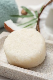 Photo of Solid shampoo bar in stone holder, closeup. Hair care