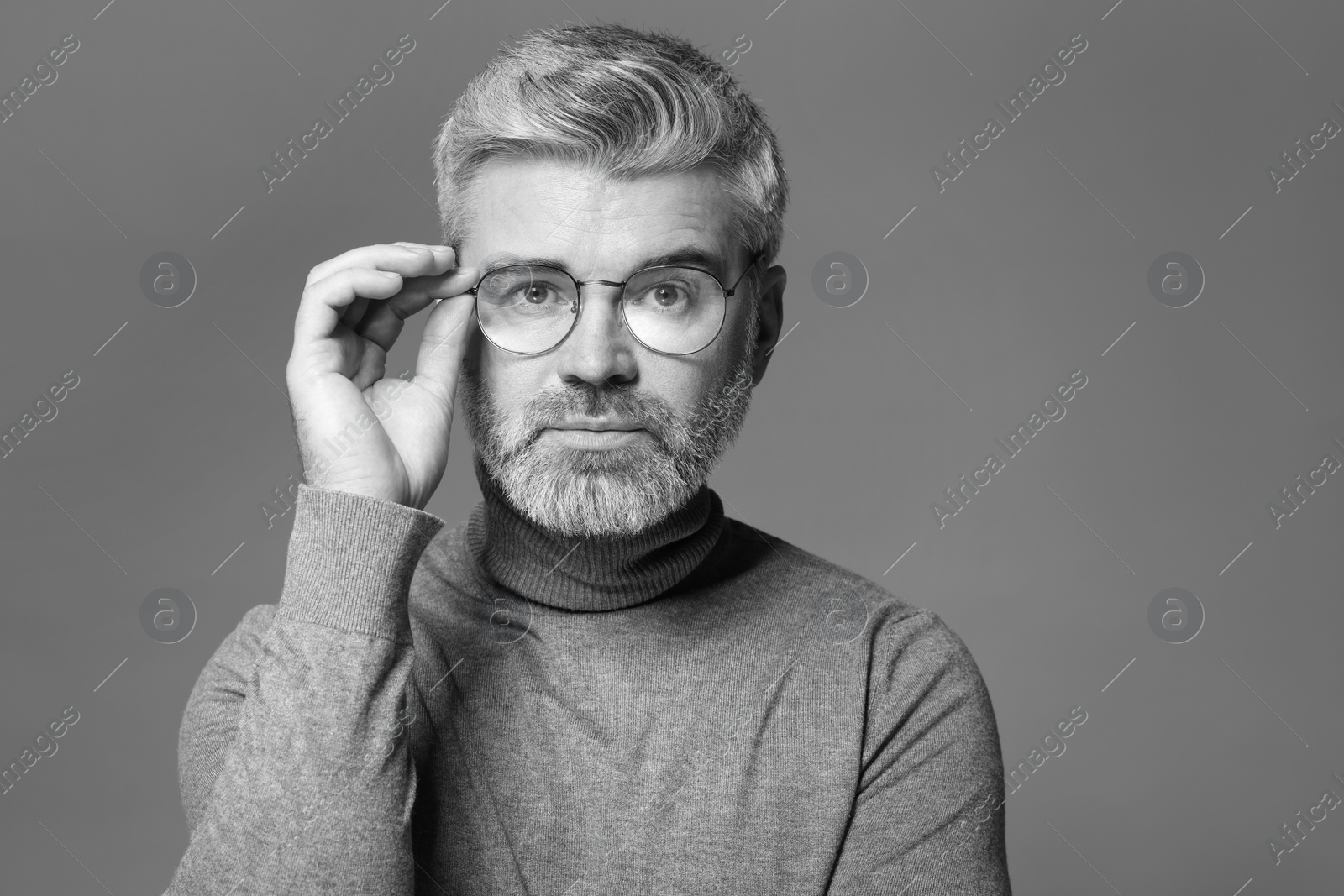 Photo of Portrait of handsome man on grey background. Black and white effect