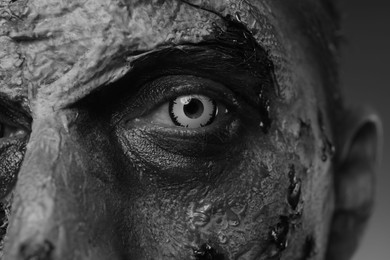 Photo of Closeup viewscary zombie on dark background, black and white effect. Halloween monster