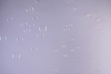 Many beautiful soap bubbles on light grey background