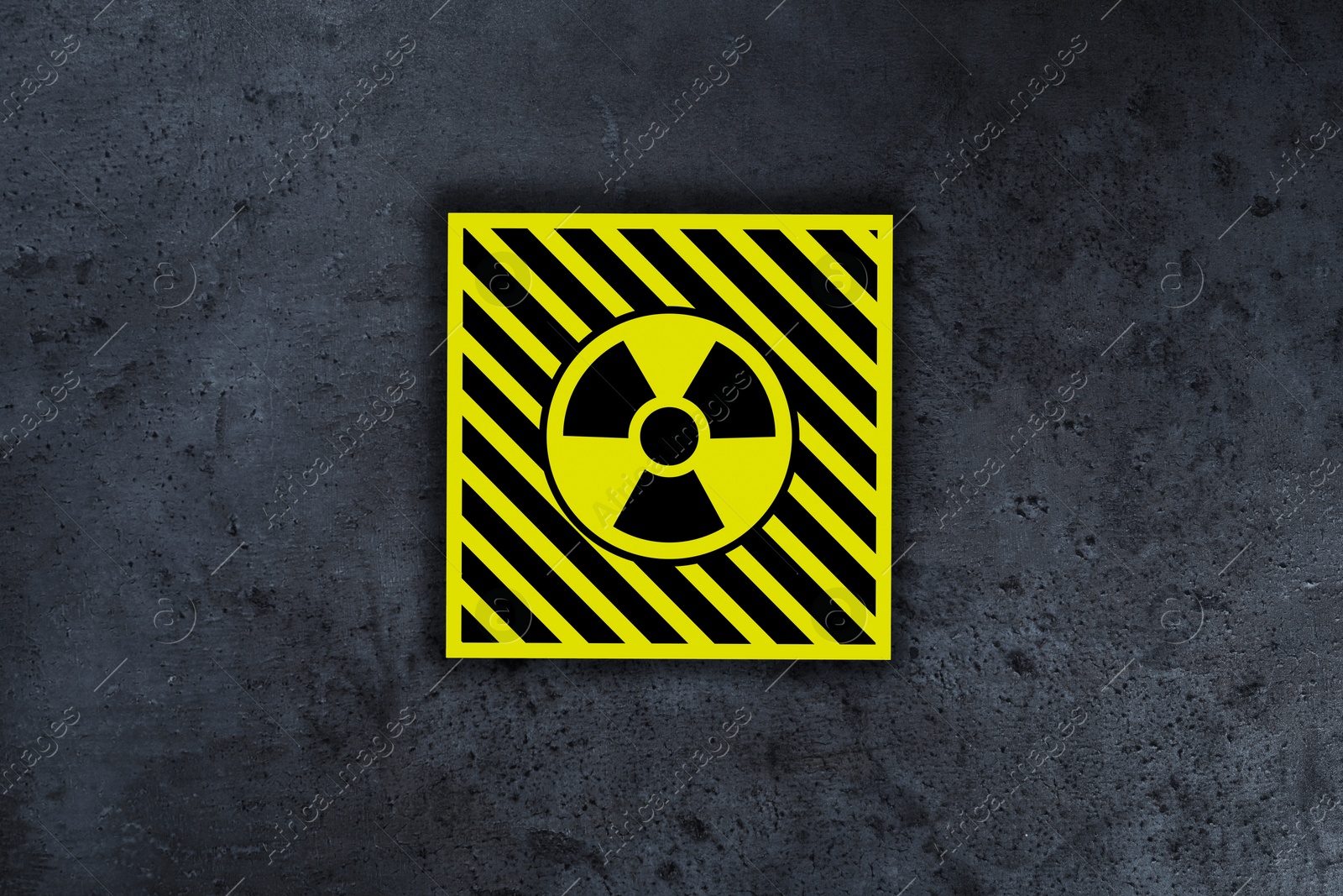 Image of Radioactive sign on grey stone wall. Hazard symbol