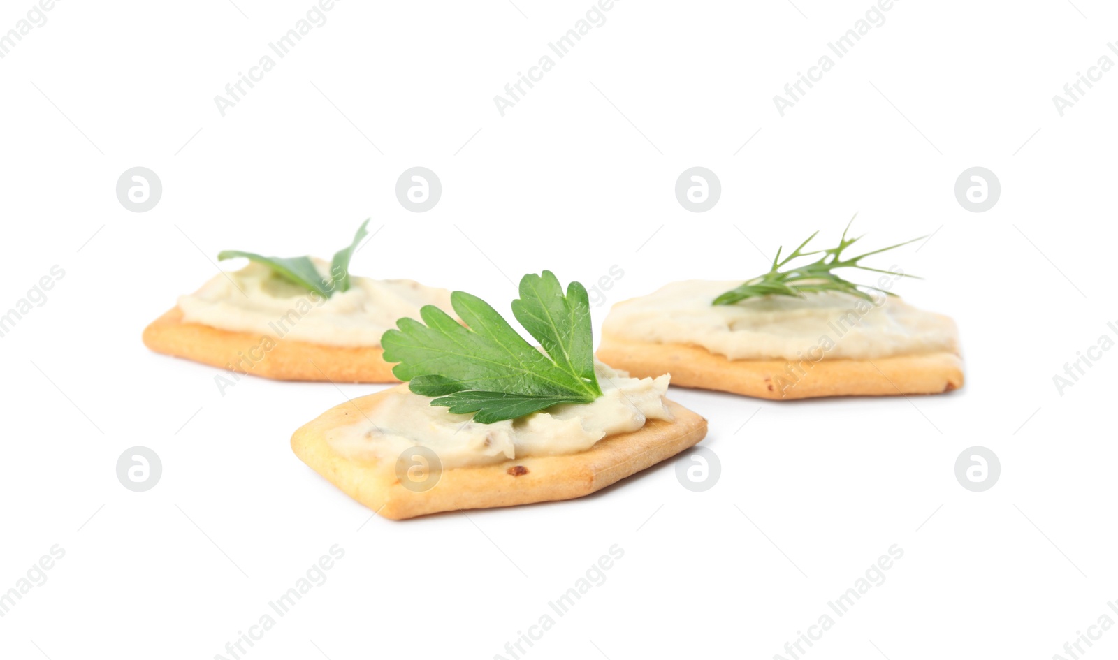 Photo of Delicious crackers with humus, parsley and dill on white background