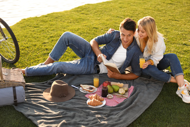 Photo of Happy young couple having picnic outdoors on sunny day