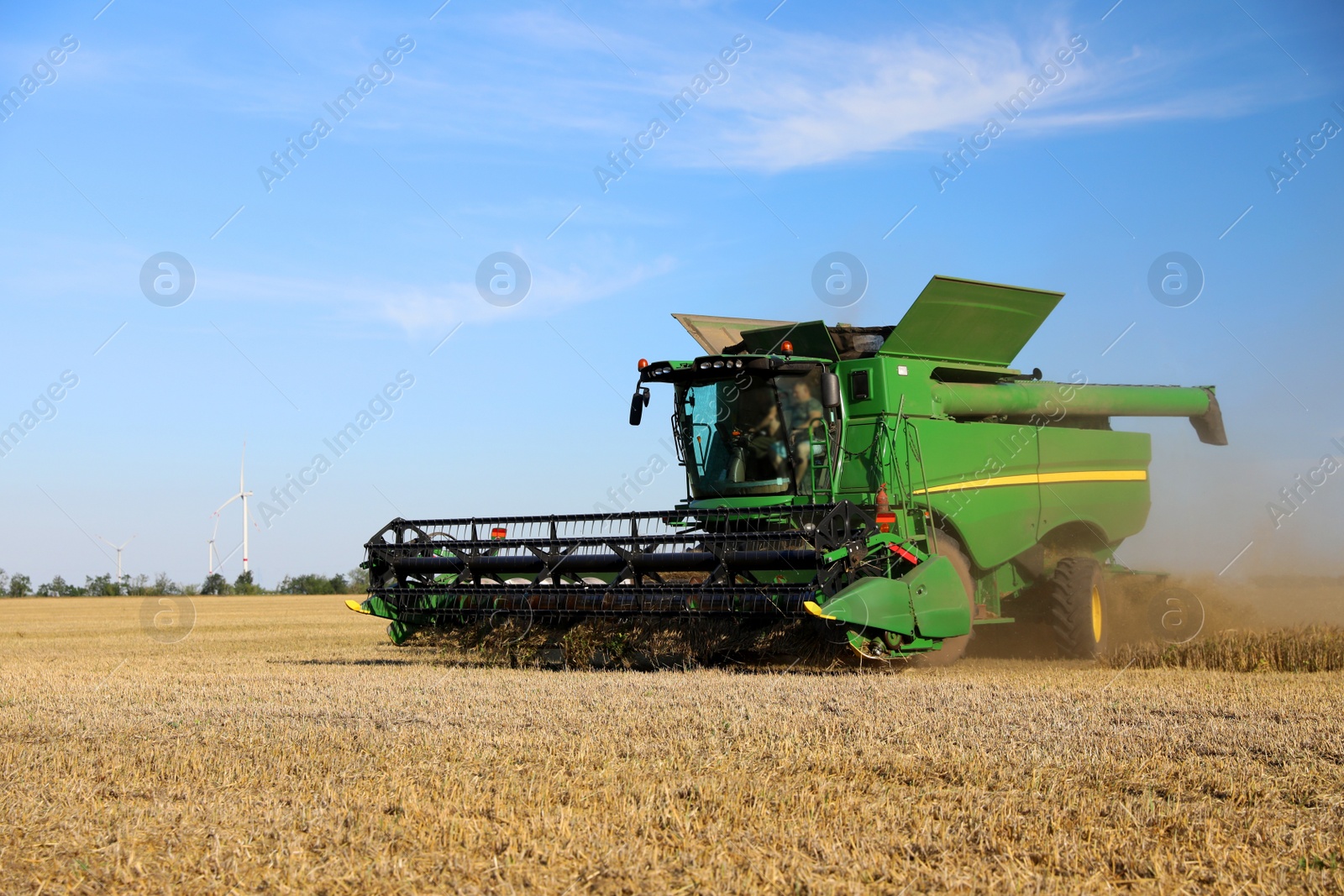 Photo of Modern combine harvester working in agricultural field