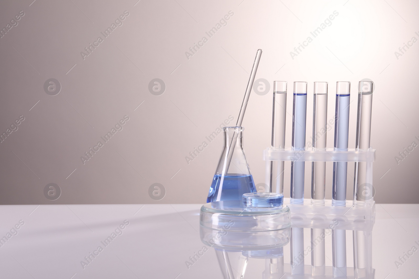 Photo of Laboratory analysis. Different glassware on table against light background, space for text