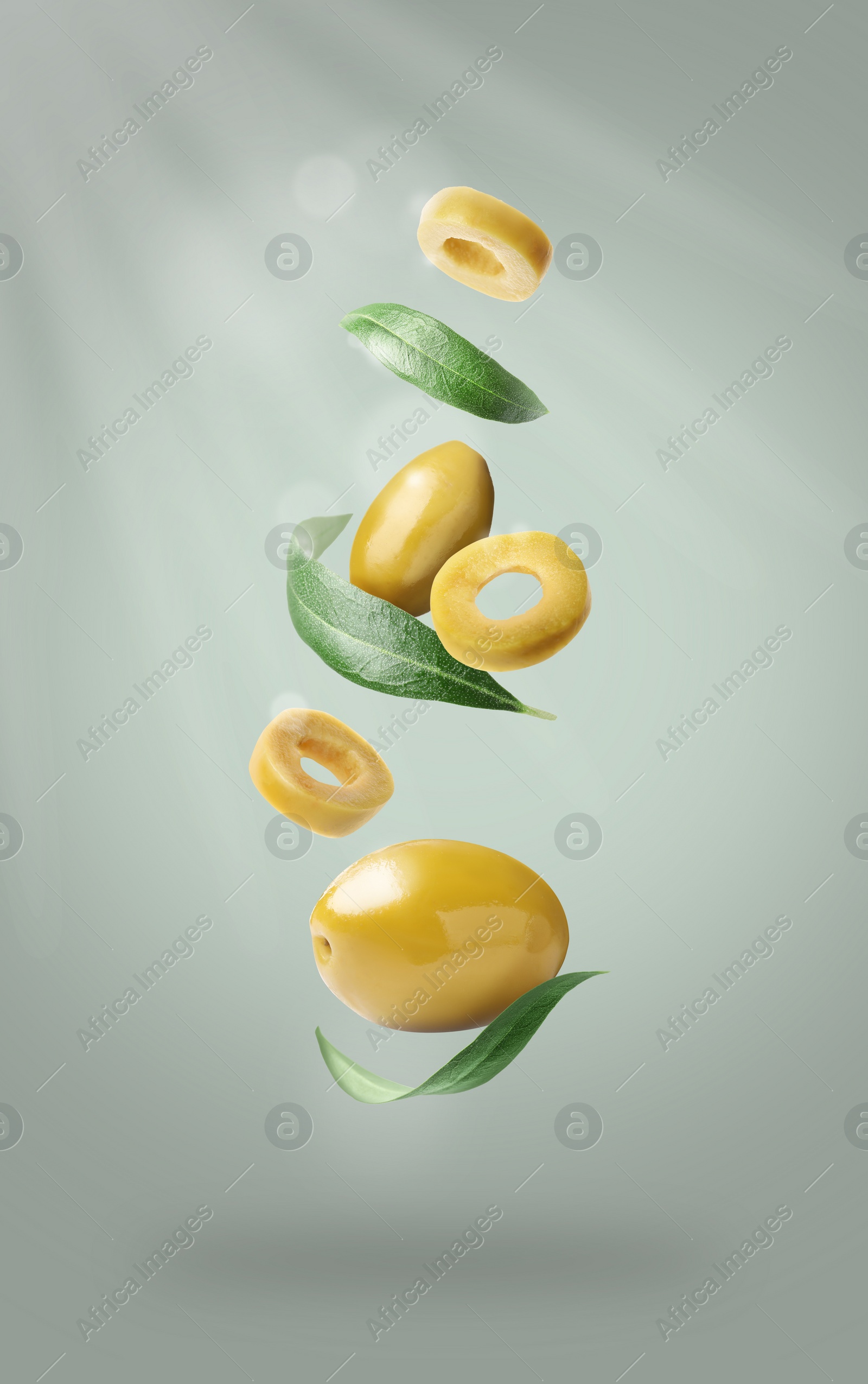 Image of Fresh olives and leaves falling on light grey background