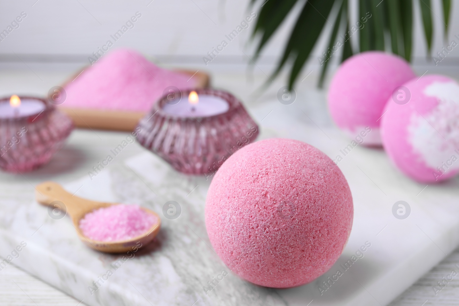 Photo of Beautiful aromatic bath bombs on white wooden table, closeup. Space for text