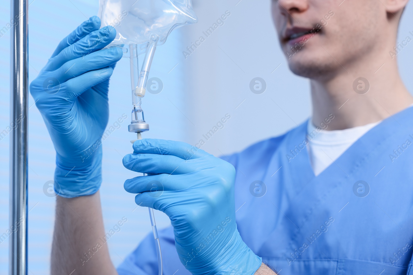 Photo of Nurse setting up IV drip in hospital, closeup